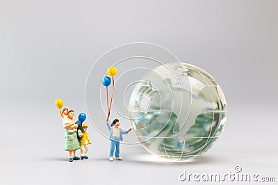 A joyful family with a balloon encircling a crystal globe and the conncept of World Earth Day Stock Photo