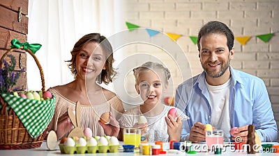 Joyful family with Easter eggs looking at camera, traditional activity, holiday Stock Photo
