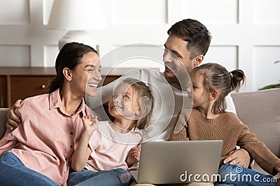 Joyful full family watching cartoons on laptop. Stock Photo