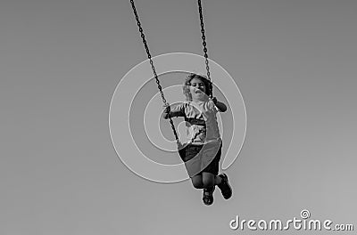 Joyful kid swinging on a swing. Happiness children. Child extreme swinging. Danger high Swing in sky. Craziness and Stock Photo