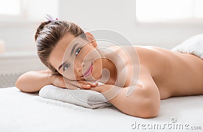 Joyful lady laying on massage table at spa salon Stock Photo