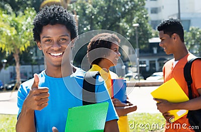 Joyful laughing african american male student showing thumb up w Stock Photo