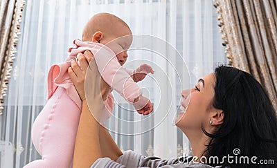 Joyful laughing mother playing with her baby. Stock Photo