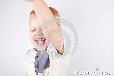 A joyful laughing three-year-old boy with a raised hand Stock Photo