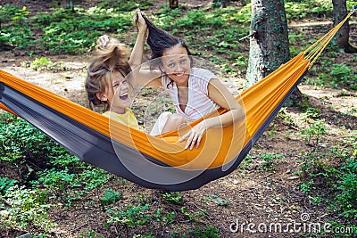 Joyful mom and daughter relax in a hammock Stock Photo