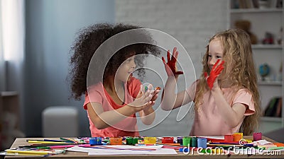 Joyful multiracial kids smudging hands with paints children art club happiness Stock Photo