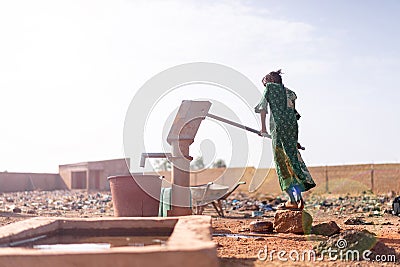 Joyful Native African Young Woman Carrying Healthy Water in a village Stock Photo