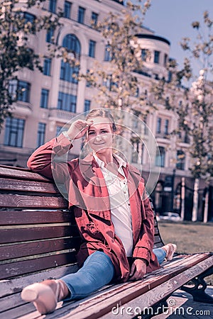 Joyful nice woman doing the splits on the bench Stock Photo