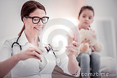 Joyful pleasant female doctor prescribing cough mixture Stock Photo