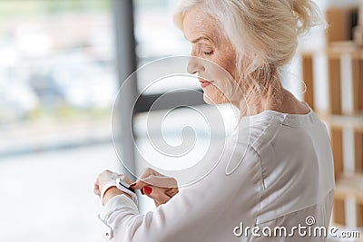 Joyful positive woman using a smartwatch Stock Photo