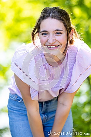 Joyful Radiance: Young Brunette Embracing Happiness in Sunlit Forest Stock Photo