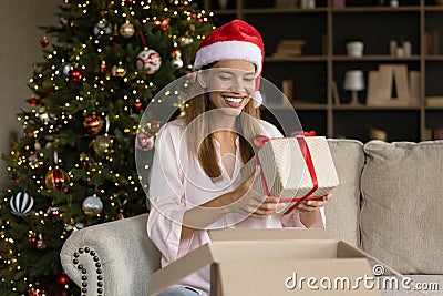 Joyful sincere young woman getting wrapped gift box. Stock Photo