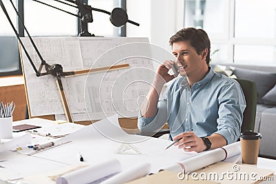 Joyful skillful architect is enjoying friendly dialogue on smartphone Stock Photo