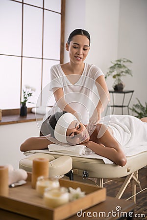 Joyful skillful woman doing body massage Stock Photo