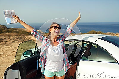 Joyful woman with a map in her hand traveling on a cabriolet Stock Photo