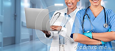 A joyful women healthcare professional in a white coat uses a laptop Stock Photo