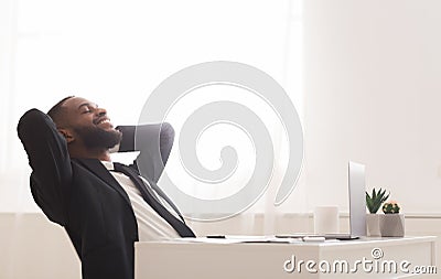 Joyful young manager relaxing on chair in white modern office Stock Photo