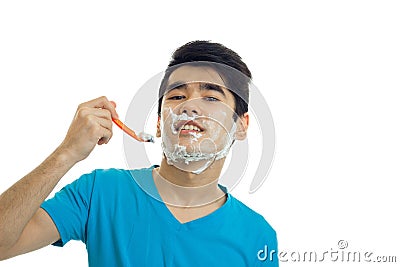 Joyful young guy with black hair tilted his head back and looks right shaves Stock Photo