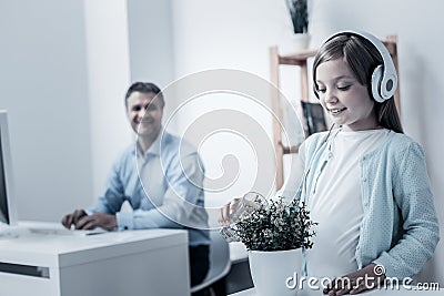 Joyful young lady watering flowers while father working Stock Photo