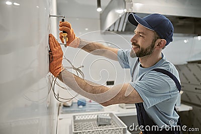 Cheerful male builder pulling out nail with pliers Stock Photo