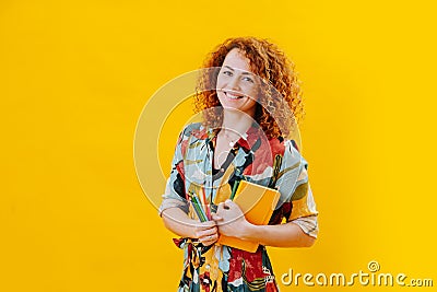 Joyful young woman holding her notebook and crayons Stock Photo