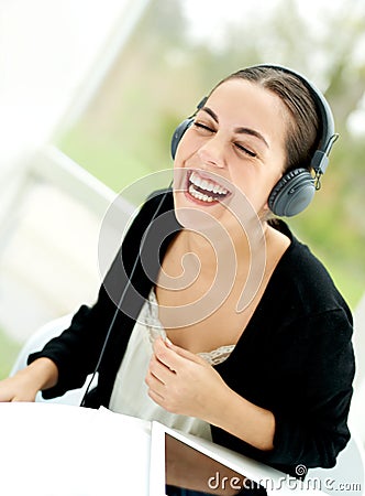 Joyful young woman laughing and listening to music Stock Photo