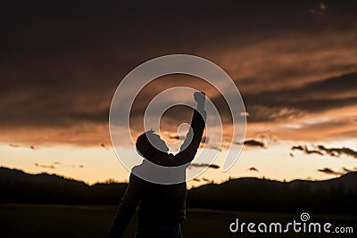 Jubilant man raising his fist against a sunset Stock Photo