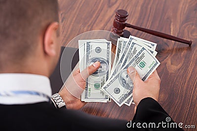 Judge Counting Dollars In Courtroom Stock Photo