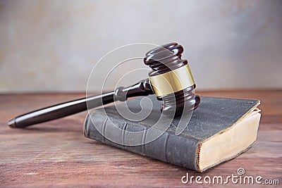 Judge gavel on an old book on a rustic wooden table, concept for Stock Photo