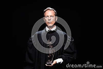 judge in judicial robe holding themis Stock Photo