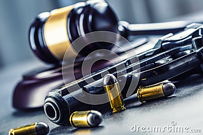 Judge's hammer gavel. Justice and gun. Justice and the judiciary in the unlawful use of of weapons. Judgment in murder Stock Photo