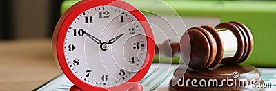 Judges hammer with red alarm clock on clipboard Stock Photo