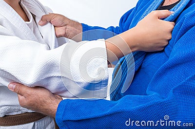 Judo Gripping between female judo brown belt and her sensei black belt Stock Photo