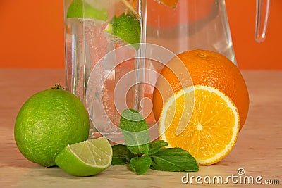 Jug, glass, citrus and mint on a table Stock Photo