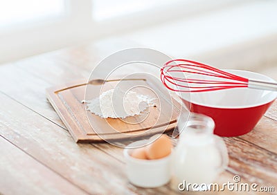 Jugful of milk, eggs in a bowl and flour Stock Photo