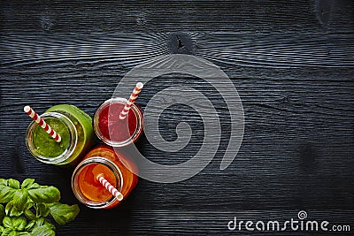 Juice bar three colorful juices with straws on dark wooden surface Stock Photo