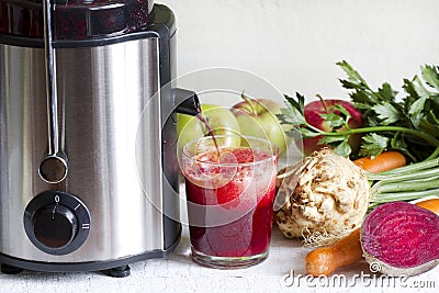 Juicer and juice with fresh fruits and vegetables Stock Photo