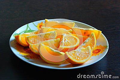 Juicy bright orange slices on a round plate Stock Photo