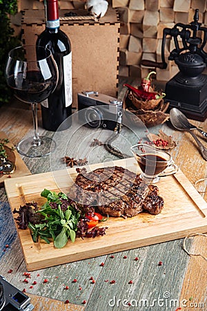 Juicy cooked ribeye steak with sauce and salad Stock Photo