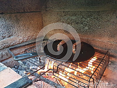 juicy cuts of meat are fried in a cast iron pan on burning coals in a barbecue oven Stock Photo