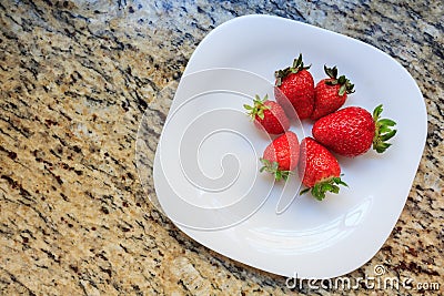 Juicy fresh strawberries in a dish white, on a marble table background, delicious dessert Stock Photo