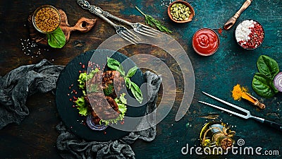 Juicy fried pork steak with spices on a black stone plate. Stock Photo