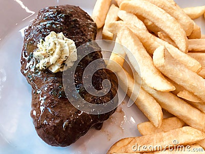 Juicy grilled steak with herb butter and french fries. Stock Photo