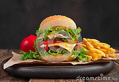 Juicy, mouthwatering burger and French fries on a brown background with space to copy. Stock Photo