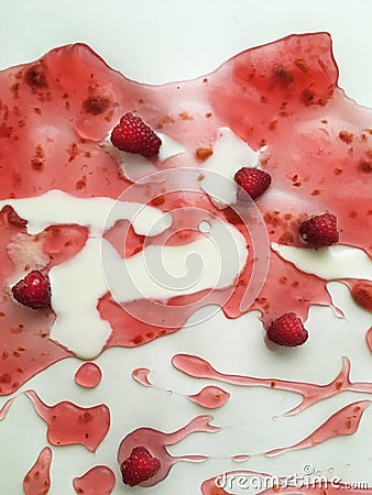 Ripe juicy raspberries of deep saturated raspberry color floating in raspberry jelly with milk on a white background as a visual e Stock Photo