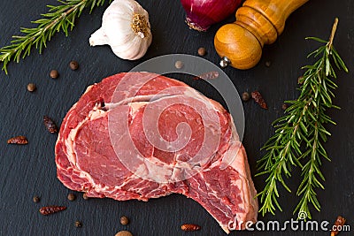 Juicy raw meat, beef entrecote on black background, top view Stock Photo