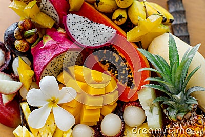 Juicy ripe tropical Thai fruits on a wooden dish. Stock Photo