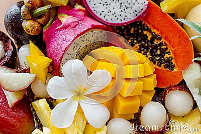Juicy ripe tropical Thai fruits on a wooden dish. Stock Photo