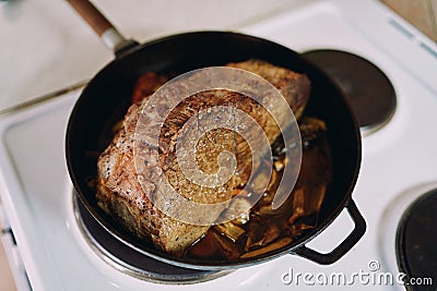 Juicy roast beef stewed in a pan on the stove Stock Photo