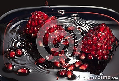 Juicy seeds of pomegranate in own juice. Close up against a dark background Stock Photo